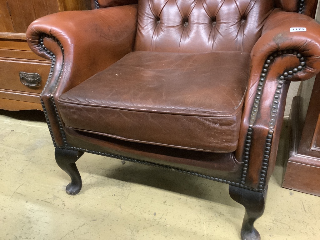 A buttoned burgundy leather wing armchair, width 86cm, depth 80cm, height 110cm